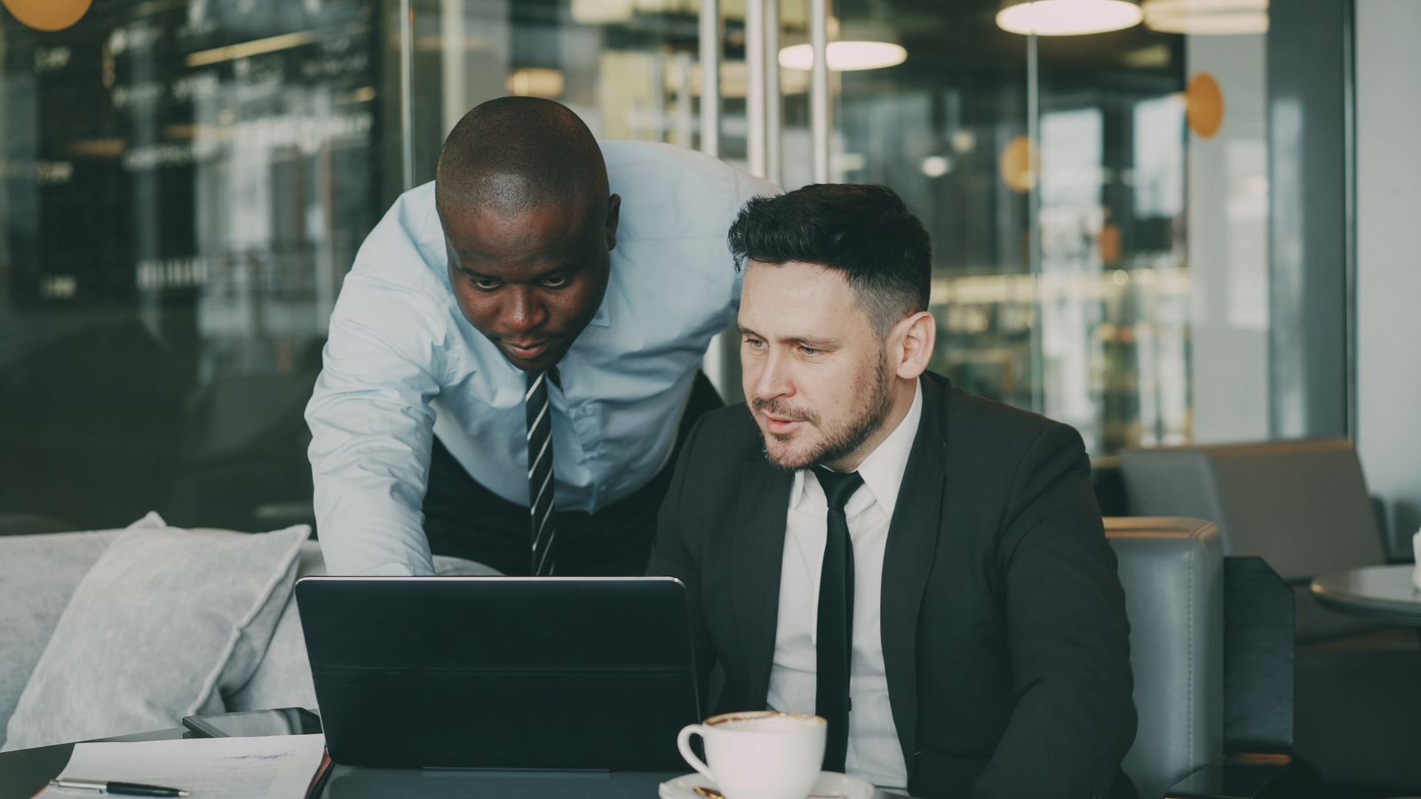 Two colleagues reviewing a compliance programme together on a laptop
